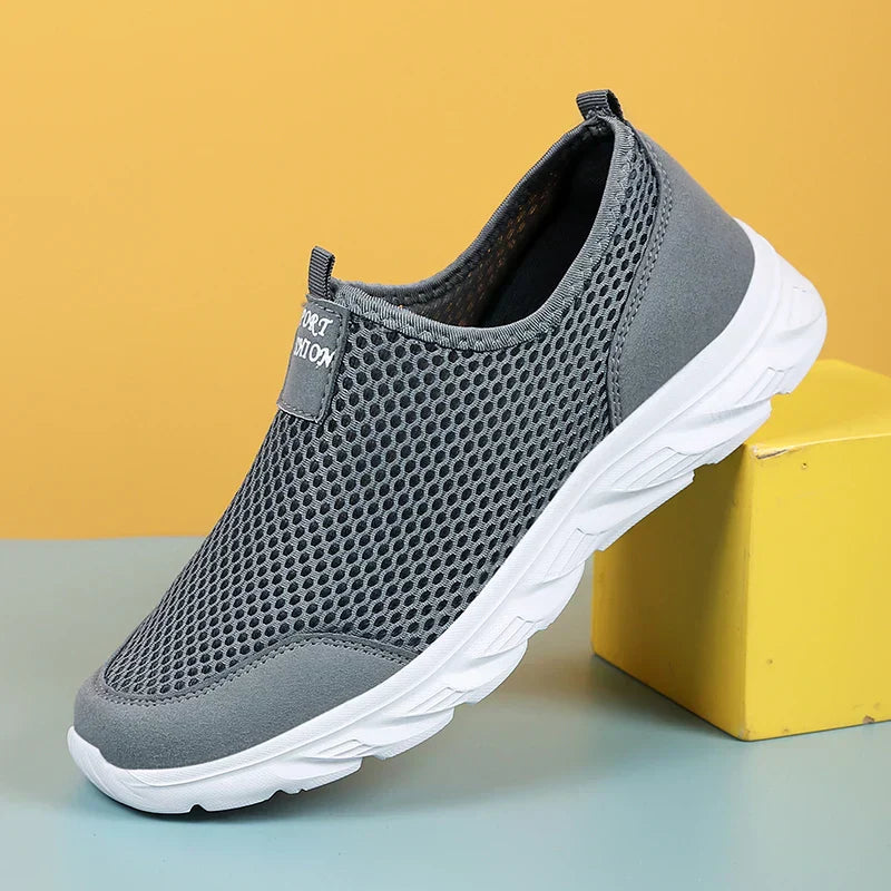 "Herrens slip-on sneakers i andningsbart material med robust gummisula, stilren design för vardag och utomhusbruk."
