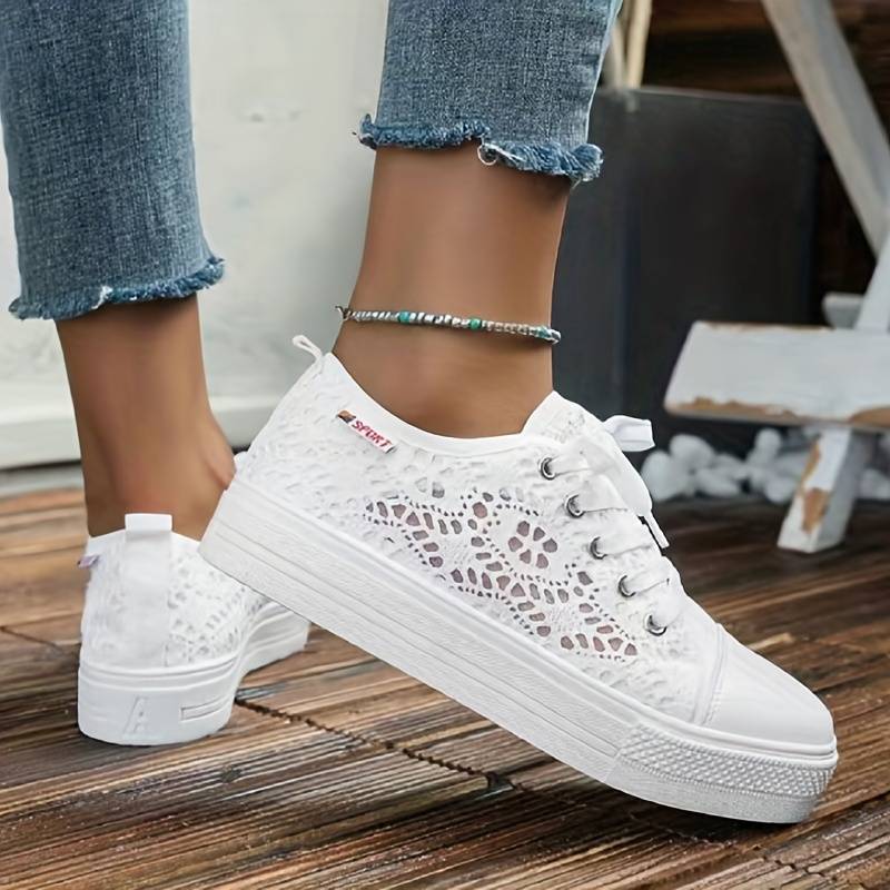 Helsotsbild av lätta svarta spetssneakers för kvinnor, modeskor för sommaren.